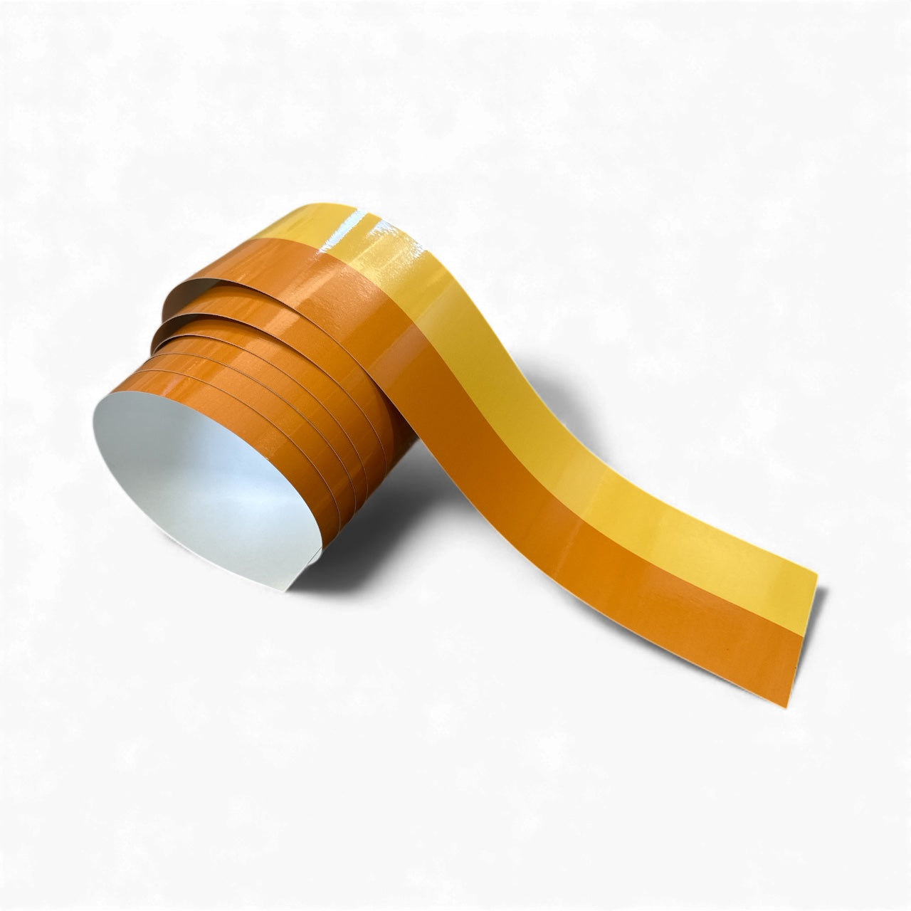 Roll of orange and yellow striped tape on a white background