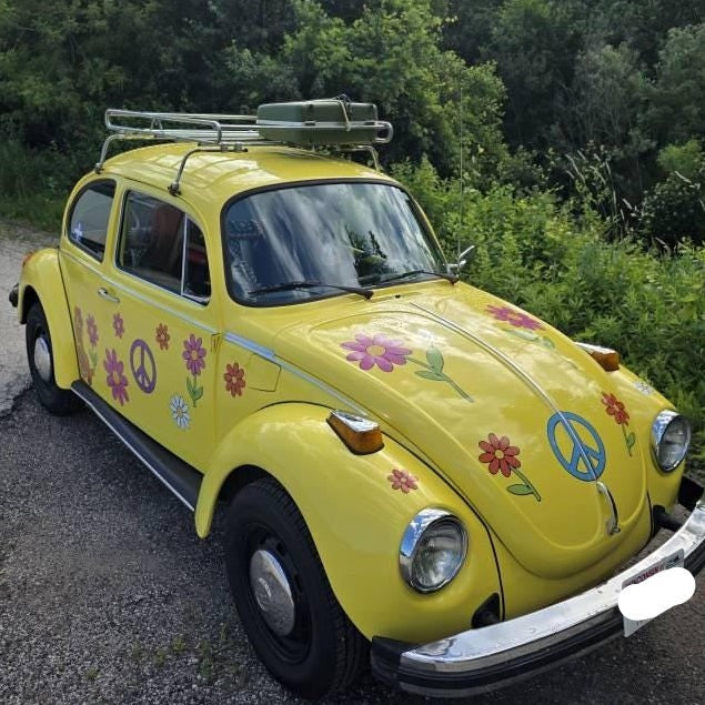 Mega Sticker Store yellow vintage Volkswagen Beetle decorated with colourful hippie flower and peace sign vinyl decals