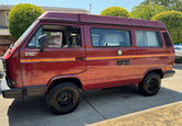 Mega Sticker Store retro orange and yellow pinstripe decal applied to the side of a maroon camper van
