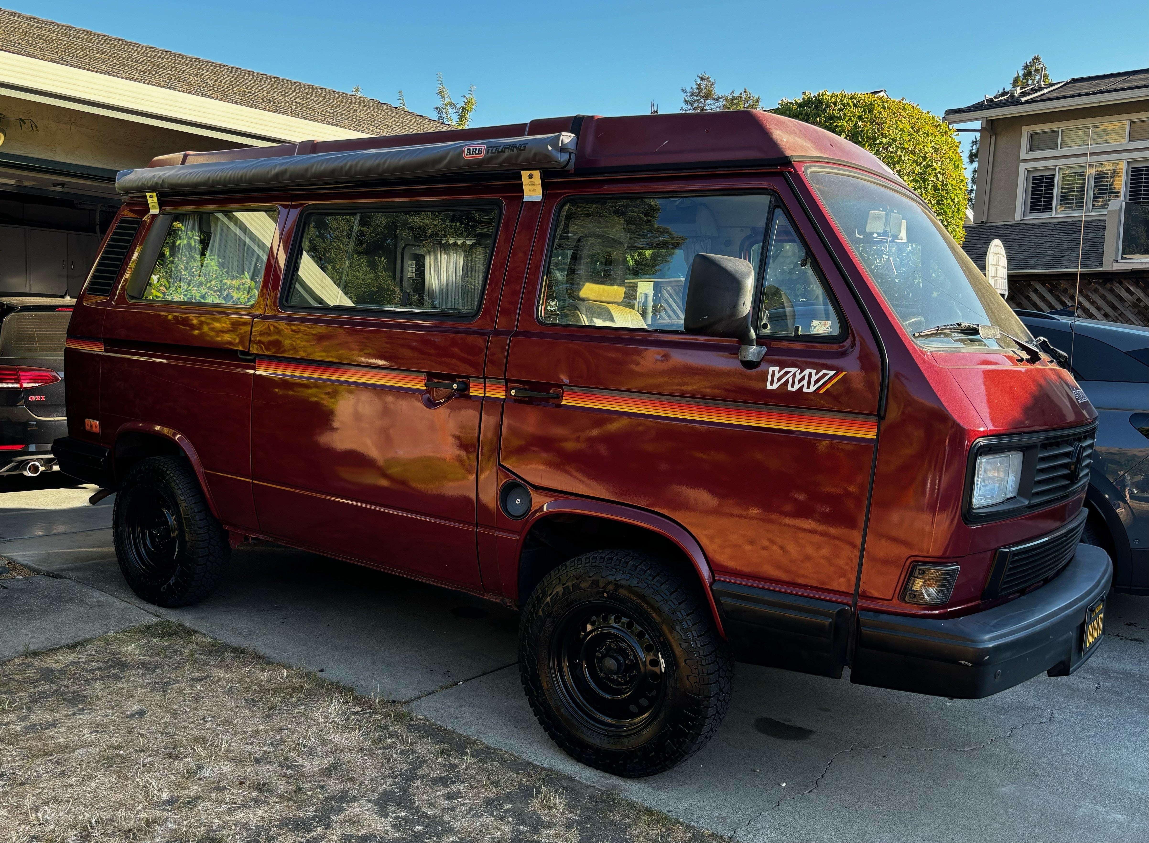 Mega Sticker Store retro pinstripe decal in orange and yellow tones applied to the side of a maroon camper van