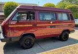 Mega Sticker Store retro orange and yellow pinstripe decal applied to the side of a maroon camper van