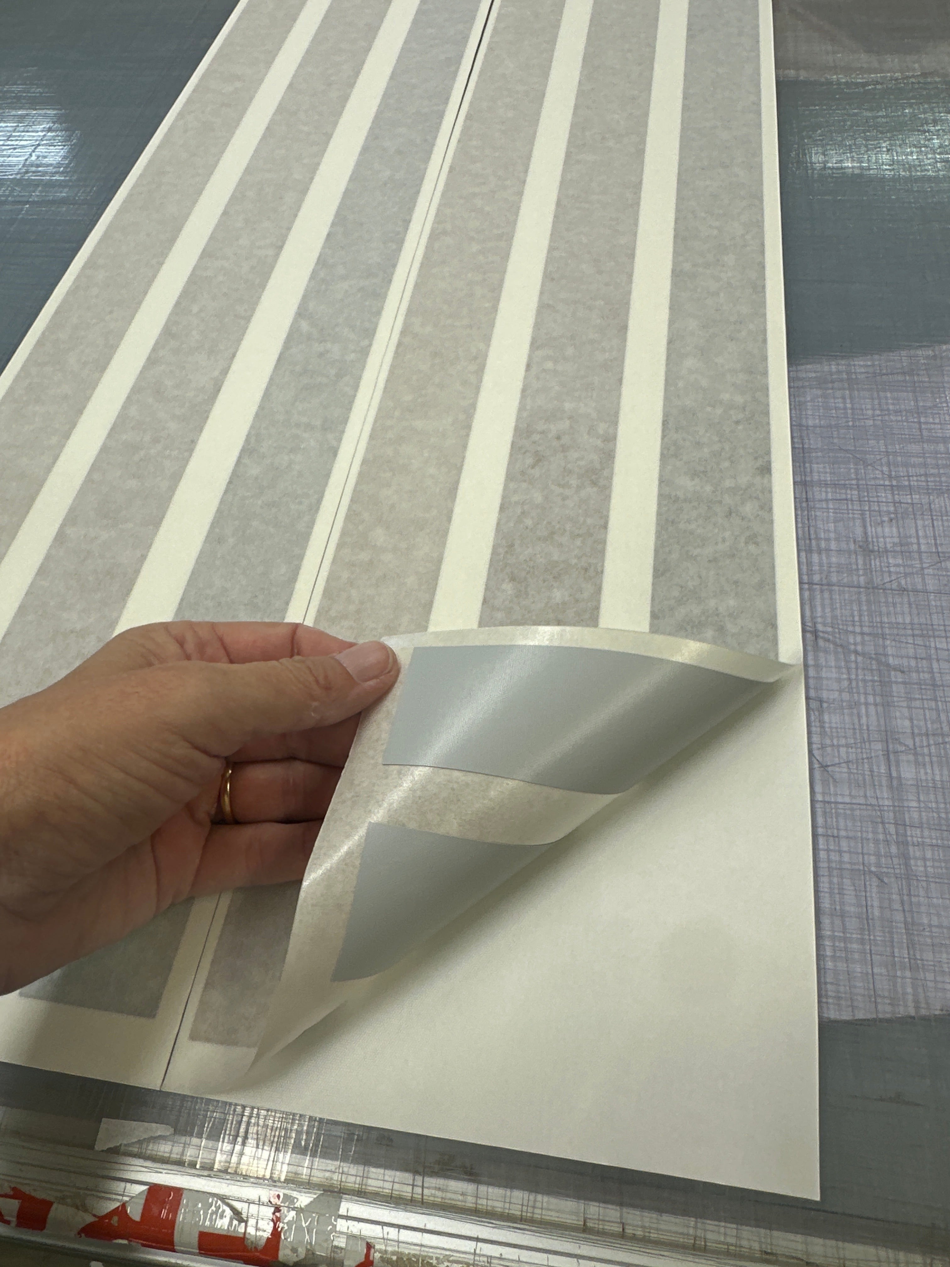 Mega Sticker Store brown and tan retro pinstripe vinyl decal being peeled from its backing paper