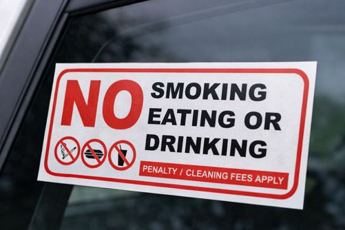 No smoking, eating, or drinking sign on a car window