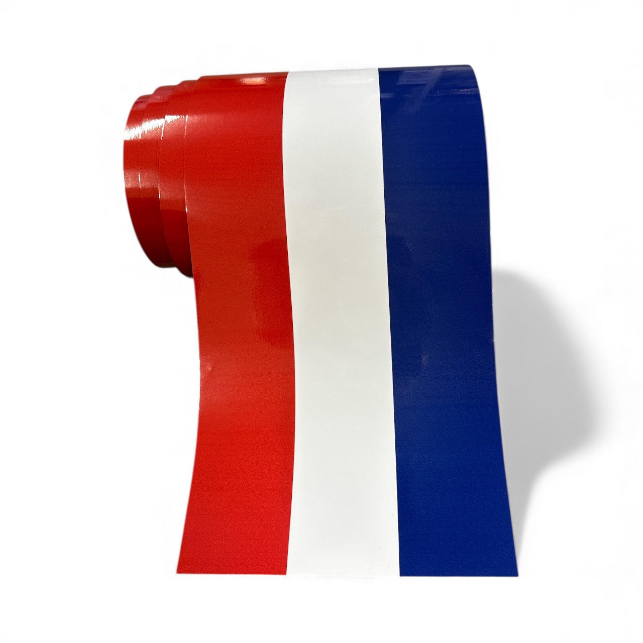 Roll of red, white, and blue tape on a white background