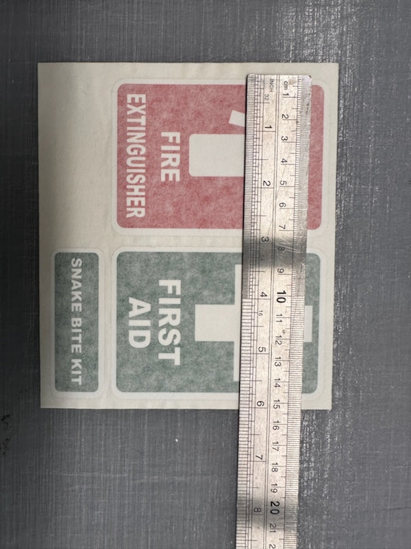 Set of three emergency stickers for vehicles or windows including fire extinguisher, first aid, and snake bite kit in red, white, and green colors.