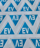 Blue EV electric vehicle safety sticker displayed beside a vehicle Licence plate