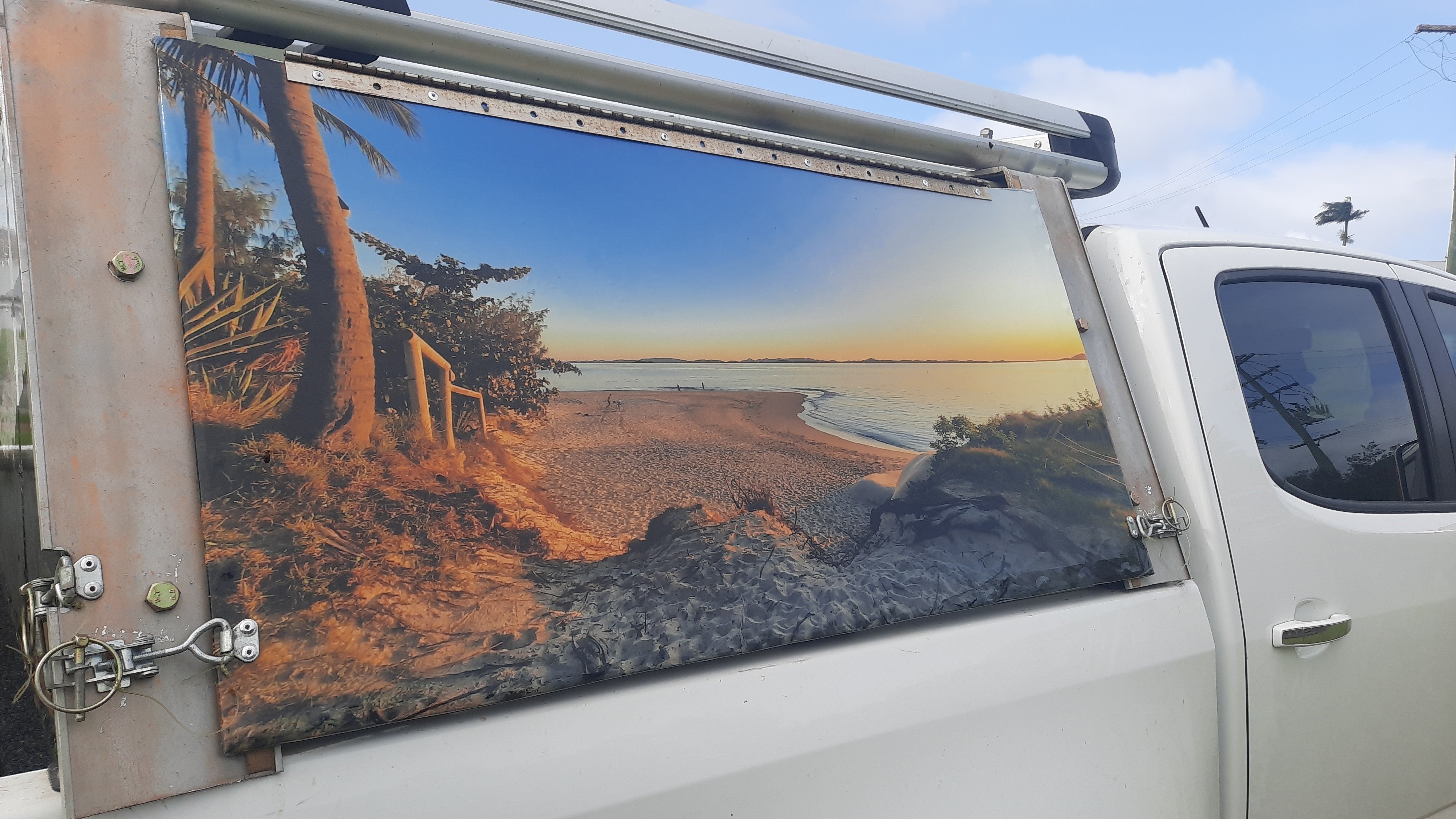 Mega Sticker Store custom vinyl decal featuring a beach sunset landscape applied to the side panel of a white 4WD ute.