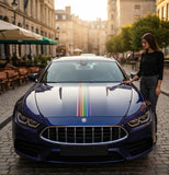 Mega Sticker Store rainbow pride pinstripe decal applied to the hood of a dark blue luxury car on a city street