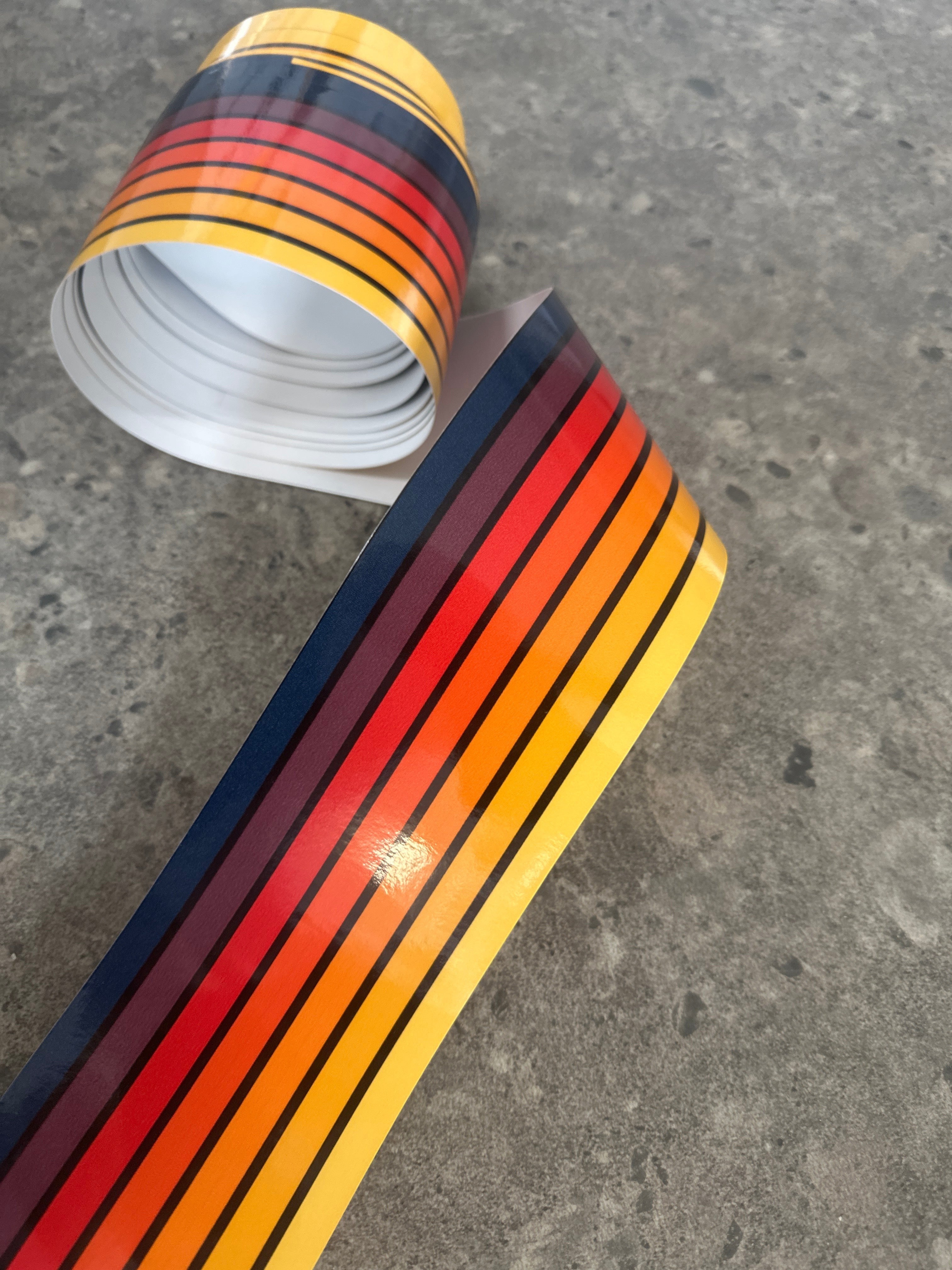 Mega Sticker Store retro pinstripe decal roll featuring vibrant orange, yellow, and brown stripes on glossy vinyl.