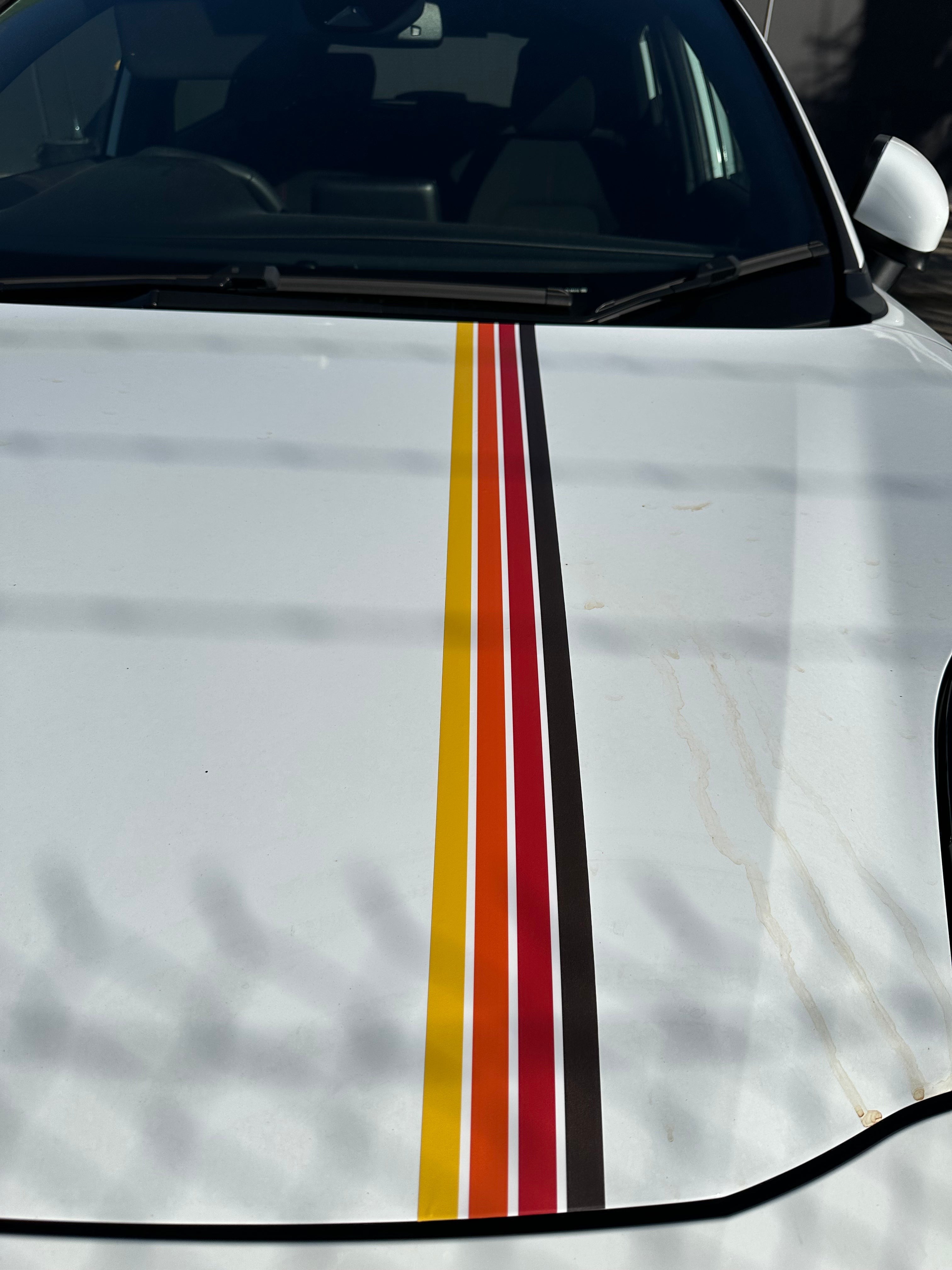 Mega Sticker Store retro pinstripe decal with orange, yellow, and black stripes on a white car hood