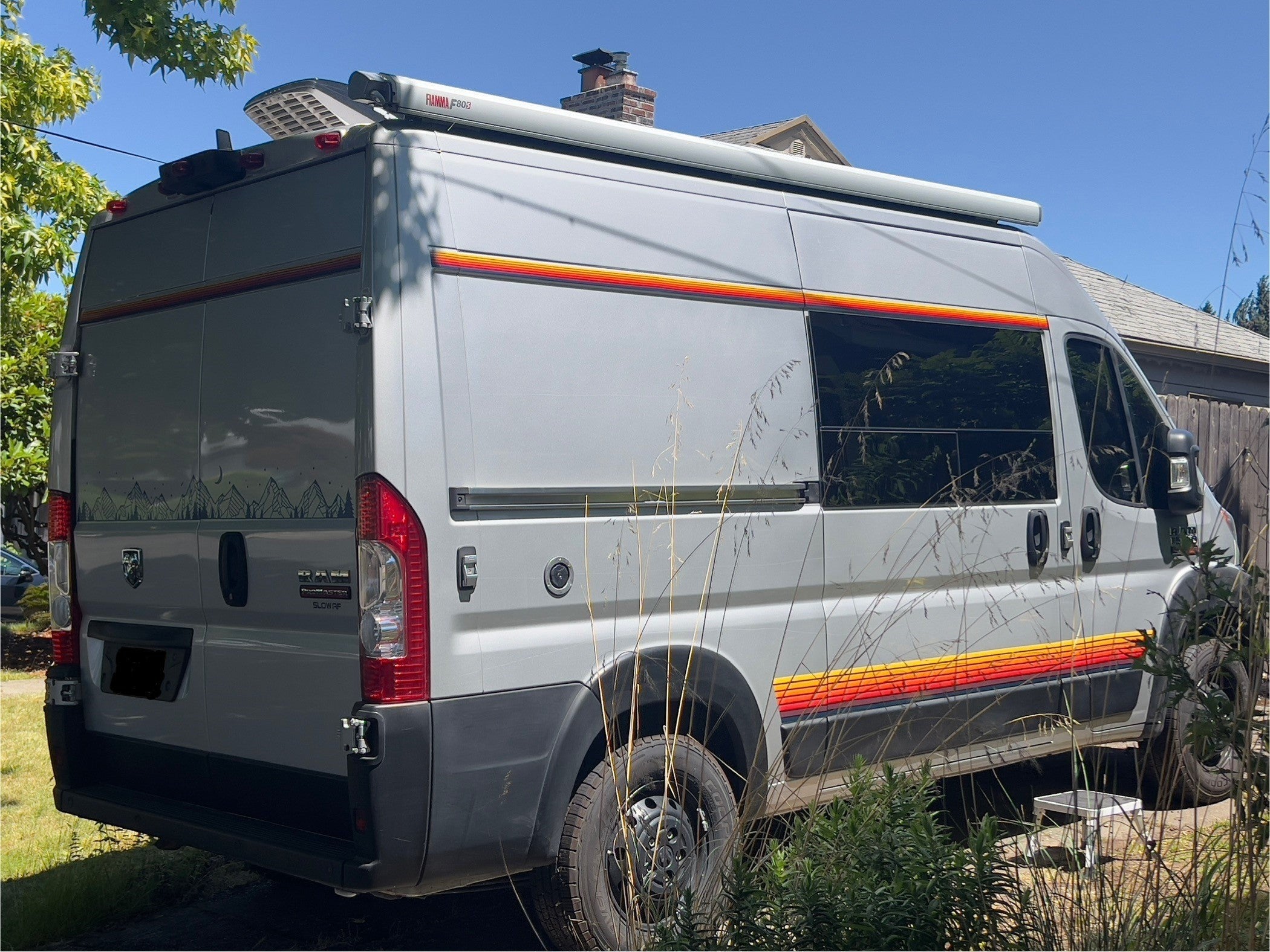 Mega Sticker Store retro pinstripe decals in orange, yellow, and brown on a grey camper van side profile