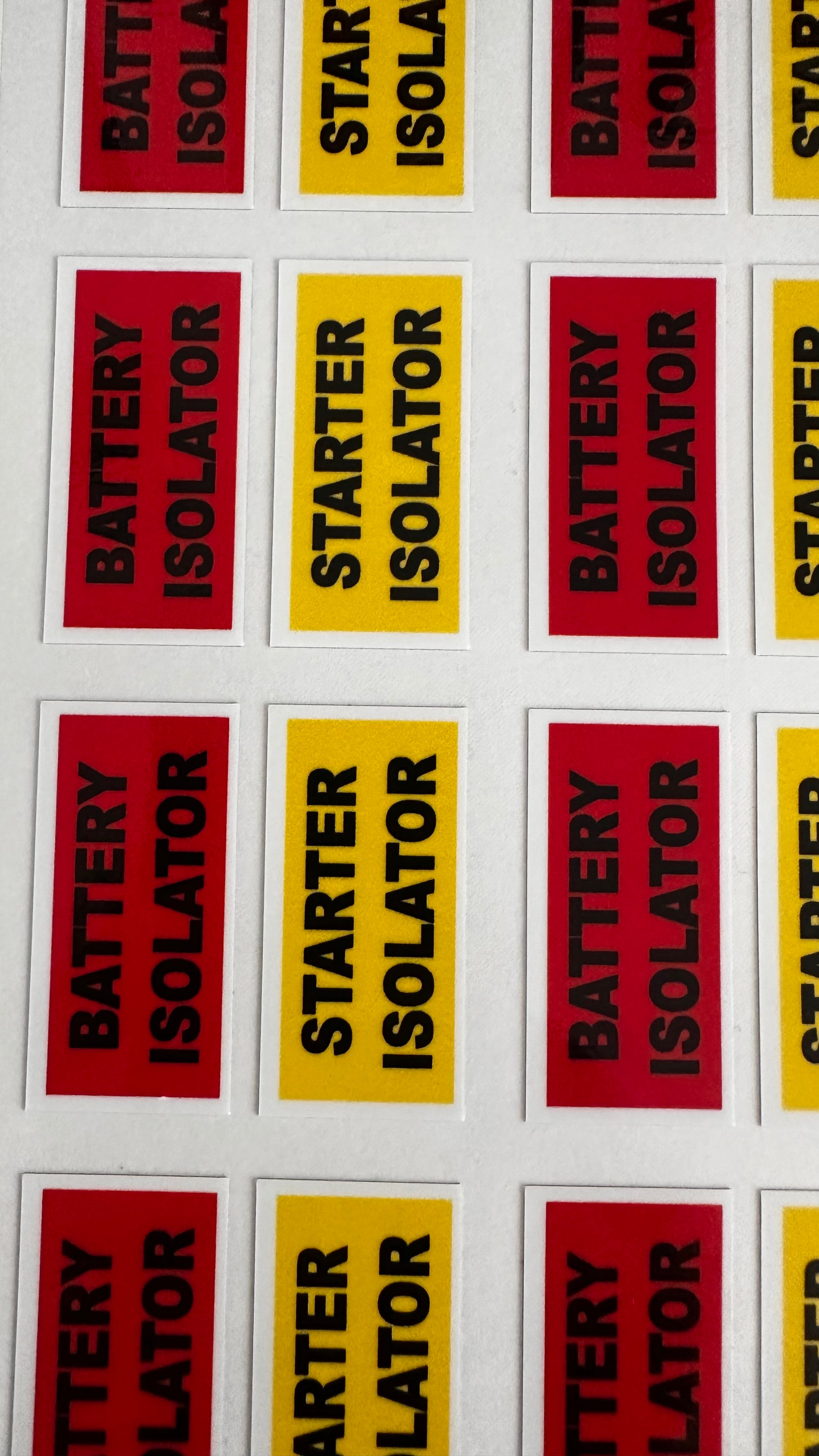 Stickers with text 'Battery Isolator' and 'Starter Isolator' in red and yellow on a white background.